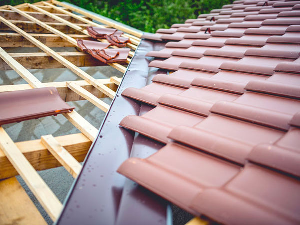 Roof building at new house construction. Brown roof tiles coveri